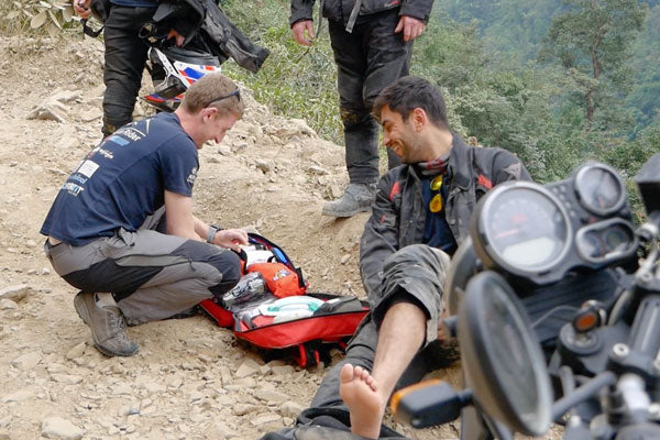 Ollie moto giving first aid to motorcycle rider