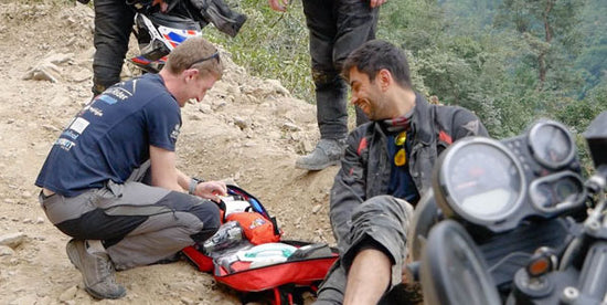 providing first aid to a motorcycle rider laying on the ground