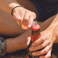Jetboil CrunchIt Fuel Can Recycling Tool being used to open bottle