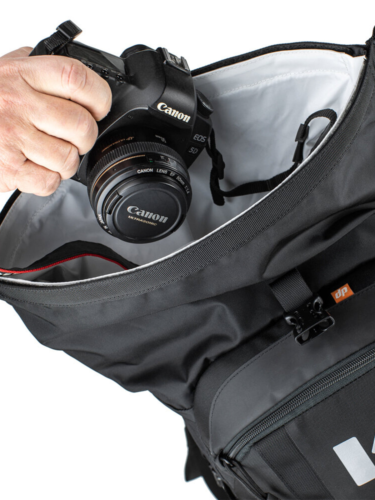 putting a dslr camera in roll top pocket of the Kriega R22 Backpack