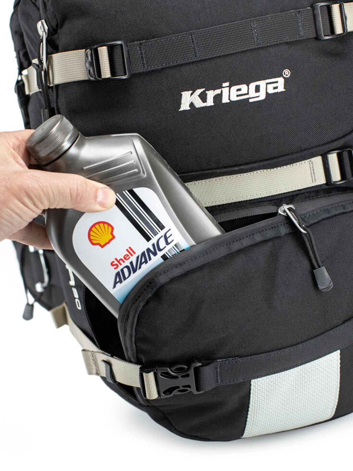 putting a bottle of oil in the Kriega R30 Backpack front pocket 