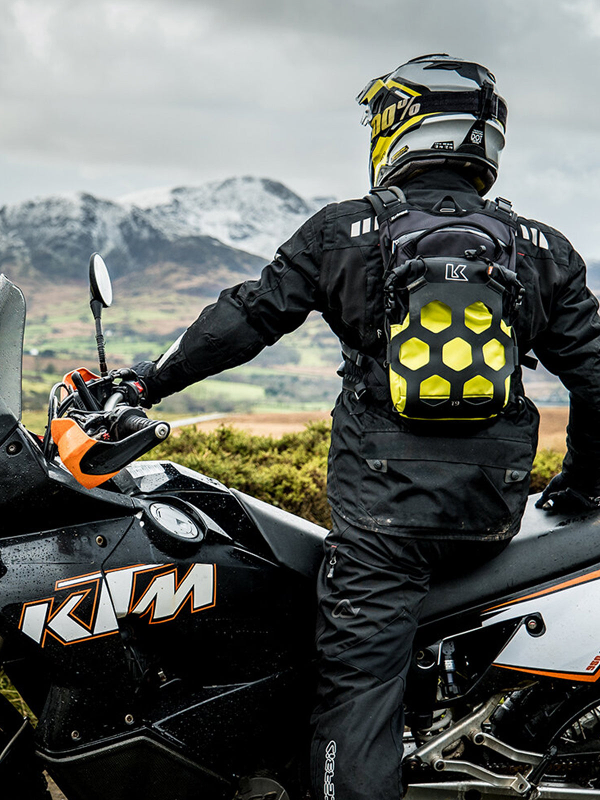 motorcycle rider on his ktm wearing a Kriega Trail9 Adventure Backpack looking at the mountains